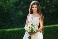 Cute young bride with long hairs holding her wedding bouquet includes white roses and other flowers. Beautiful white Royalty Free Stock Photo