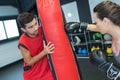 Cute young brunette getting boxing lessons from coach