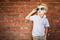 Cute Young Caucasian Boy in Sunglasses Against Brick Wall