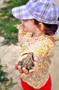 A cute young child girl holding a frog toad in hands and laughing Royalty Free Stock Photo