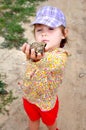 A cute young child girl holding a frog toad in hands and laughing Royalty Free Stock Photo