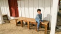 Cute Young Chinese Caucasian Boy Sitting On a Rustic Bench Royalty Free Stock Photo