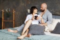 Cute young couple drinking morning coffee lying in bed. Love and relationships, husband and wife Royalty Free Stock Photo