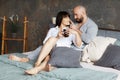 Cute young couple drinking morning coffee lying in bed. Love and relationships, husband and wife Royalty Free Stock Photo