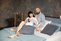 Cute young couple drinking morning coffee lying in bed. Love and relationships, husband and wife Royalty Free Stock Photo