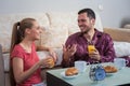 Cute young couple having breakfast, eating croissants, drinking orange juice. Royalty Free Stock Photo