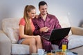 Cute young couple having breakfast, in front of laptop computer Royalty Free Stock Photo