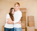 Cute young couple hugging on a background of cardboard boxes Royalty Free Stock Photo