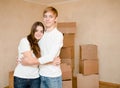 Cute young couple hugging on a background of cardboard boxes Royalty Free Stock Photo