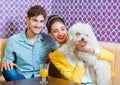 Cute young couple sitting at the table with a puppy Royalty Free Stock Photo