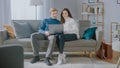 Cute Young Couple Use Laptop Computer, while Sitting on the Couch in the Cozy Apartment. Couple Royalty Free Stock Photo