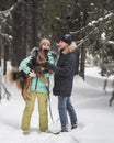 Cute couple walking and having fun with their dog in winter forest Royalty Free Stock Photo