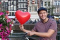 Cute young ethnic guy holding a heart-shaped balloon Royalty Free Stock Photo