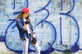 Cute young fair-haired girl teenager in a baseball cap and denim shirt on a stone wall background. Royalty Free Stock Photo