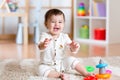 Cute young girl baby playing home with colorful toys Royalty Free Stock Photo