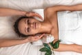 Cute young girl with closed eyes, thick eyebrows and perfect skin during neck massage, woman relaxing at white towel background, Royalty Free Stock Photo