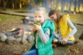 Cute young girl drinking tea and roasting marshmallows on stick at bonfire. Child having fun at camp fire. Camping with children Royalty Free Stock Photo