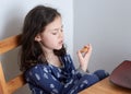 pretty young girl eating bread and butter in her pajamas at breakfast