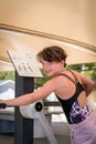 Cute young girl exercising upper body on gym training machine outdoors. Royalty Free Stock Photo