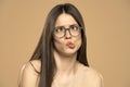 Cute young girl with eyeglasses making funny face over pink background Royalty Free Stock Photo