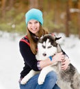 Cute young girl with hasky dog in winter forest