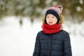 Cute young girl having fun on a walk in snow covered pine forest on chilly winter day. Child exploring nature Royalty Free Stock Photo