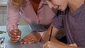 Cute young girl and her teacher working on art project together Royalty Free Stock Photo