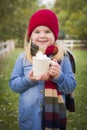 Cute Young Girl Holding Cocoa Mug with Marsh Mallows Outside