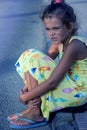 Cute young girl looking sad, alone, scared, abuse, homeless is sitting on the ground. Evening time. Nice sunlight. 1 Royalty Free Stock Photo