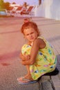 Cute young girl looking sad, alone, scared, abuse, homeless is sitting on the ground. Evening time. Nice sunlight. 2 Royalty Free Stock Photo