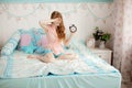 Cute young girl in nice children's bedroom with alarm clock Royalty Free Stock Photo