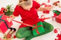 Cute young girl opening christmas present while sitting on living room floor. Candid family christmas time background. Royalty Free Stock Photo