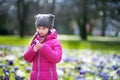 Cute young girl picking crocus flowers on beautiful blooming crocus meadow Royalty Free Stock Photo