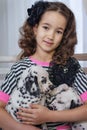 Cute young girl playing with puppies of dalmatian. Indoors. Studio portrait.