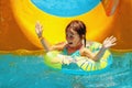 Cute young girl into pool after going down water slide during summer. Summer holiday, adventure and happy childhood concept Royalty Free Stock Photo