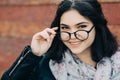 Beautiful happy hipster girl goes in the city. Closeup of trendy girl face. Royalty Free Stock Photo