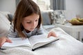 Cute young girl reading book at home Royalty Free Stock Photo