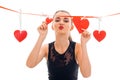 Cute young girl sends kiss and keeps the Ribbon with hearts