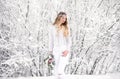 Cute young girl in winter snow forest outdoors with beautiful flowers on her head Royalty Free Stock Photo