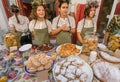 Cute young girls selling cookies, cakes and pies during a local street festival on Tbilisi