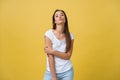 Cute young happy dreaming woman in white t-shirt isolated on yellow background giving air-kiss Royalty Free Stock Photo