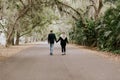 Cute Young Happy Loving Couple Walking Down an Old Abandoned Road with Mossy Oak Trees Overhanging