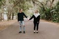 Cute Young Happy Loving Couple Walking Down an Old Abandoned Road with Mossy Oak Trees Overhanging Royalty Free Stock Photo
