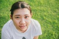 Cute young innocent asian teen smile with green grass