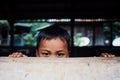 cute young kid hiding behind a wall peaking his head just above