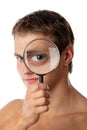 Cute young man looking through a magnifying glass Royalty Free Stock Photo