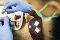 Cute young man smiling looking camera. Female dentist checking patient teeth with mirror in modern dental clinic Royalty Free Stock Photo