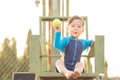 cute young mixed race boy sitting on a tennis umpire chair