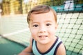 cute young mixed race boy smiling in the sun on the court Royalty Free Stock Photo