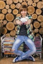 Cute young short-haired girl sits and holding toy lamb on a rustic bench. Wooden background. Farming concept. Royalty Free Stock Photo